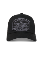 Alpinestars Heritage Patch Trucker Hat in Black and Gray, featuring a curved bill, mesh back, and embroidered racing logo.