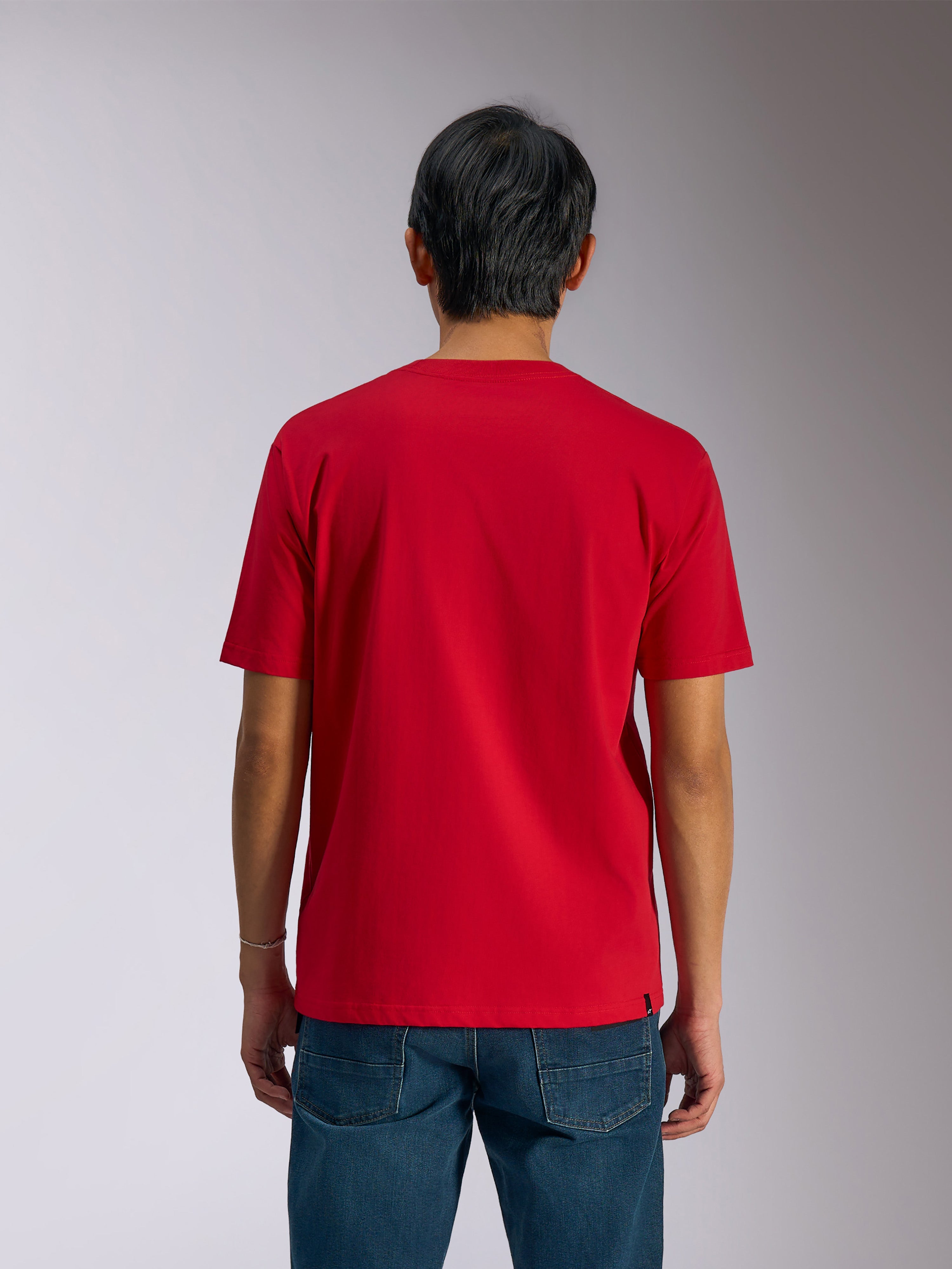 Alpinestars Ageless Shadow CSF Tee, Rückansicht, kurzärmeliges T-Shirt, Rot, lässige Motorsport-Streetwear, getragen mit blauen Jeans