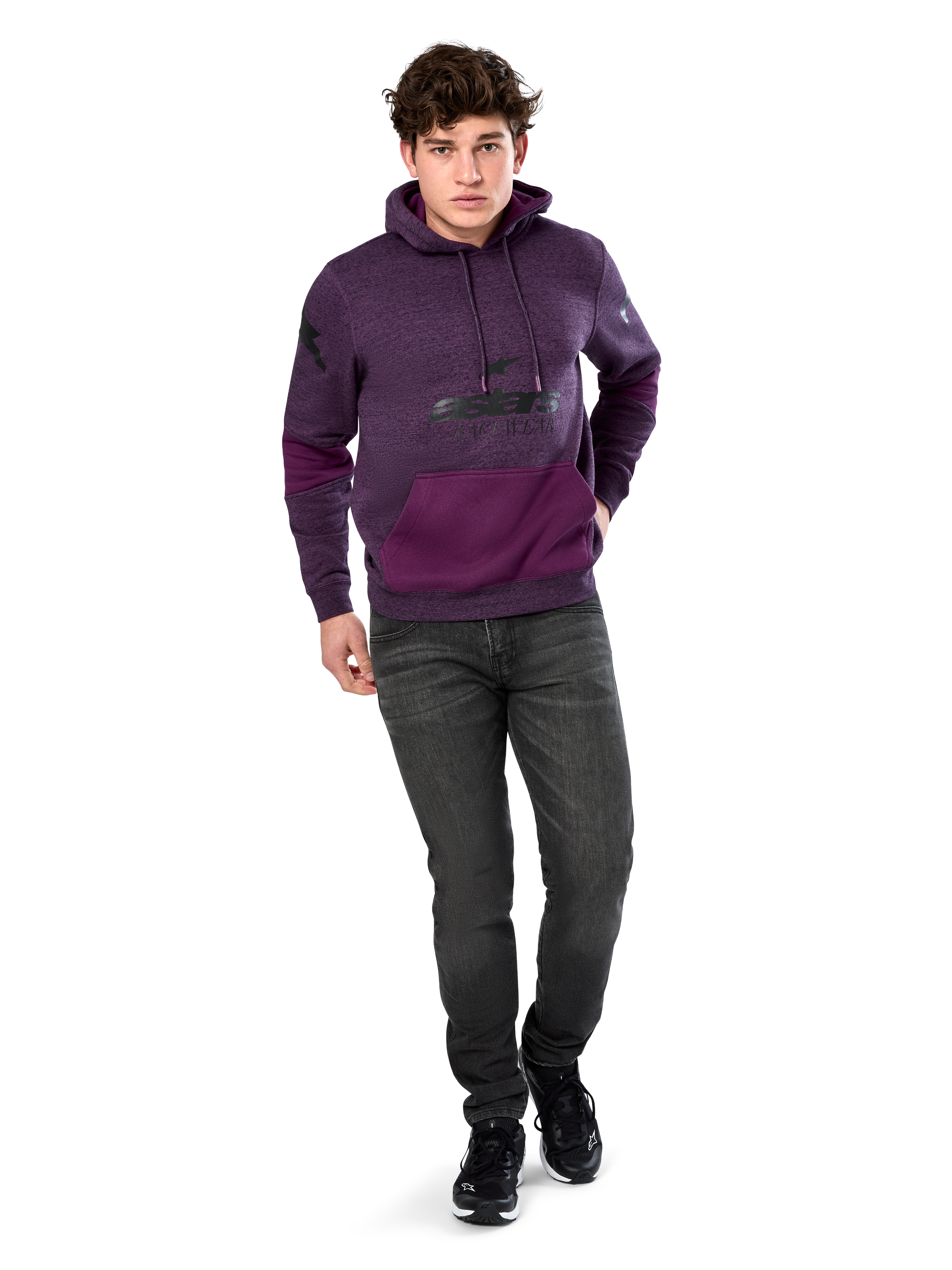 Alpinestars Perpetuate Hoodie, casual streetwear, purple heather fleece with dark purple fabric blocking on the kangaroo pocket and sleeves, black chest logo, drawstring hood, worn by model with dark grey jeans and black sneakers