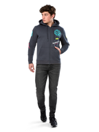 Alpinestars Variegate Hoodie, zip-front fleece hoodie, Gunmetal gray, worn by model with black jeans and sneakers, featuring teal 'ASTARS' branding and colorful logo art on sleeves and chest, casual motorsport-inspired streetwear