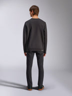Alpinestars Positive Crew, schwarzes Sweatshirt, Rückansicht an einem männlichen Model, getragen mit schwarzen Jeans und lässigen Sneakern, mit Rippbündchen an Ärmeln und Saum, Motorsport-inspirierte Streetwear