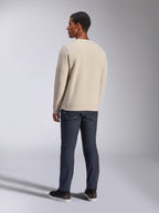 Alpinestars Positive Crew, Off-White Rundhals-Sweatshirt, Rückansicht am Modell, kombiniert mit dunklen Denim-Jeans und schwarzen Sneakern, lässige Motorsport-Streetwear, mit gerippten Bündchen und Saum