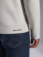 Alpinestars Positive Crew Sweatshirt, Off-White, Nahaufnahme von Rippsaum und Ärmelbündchen, mit kleinem schwarzem Alpinestars-Logo, lässige, vom Motorsport inspirierte Bekleidung