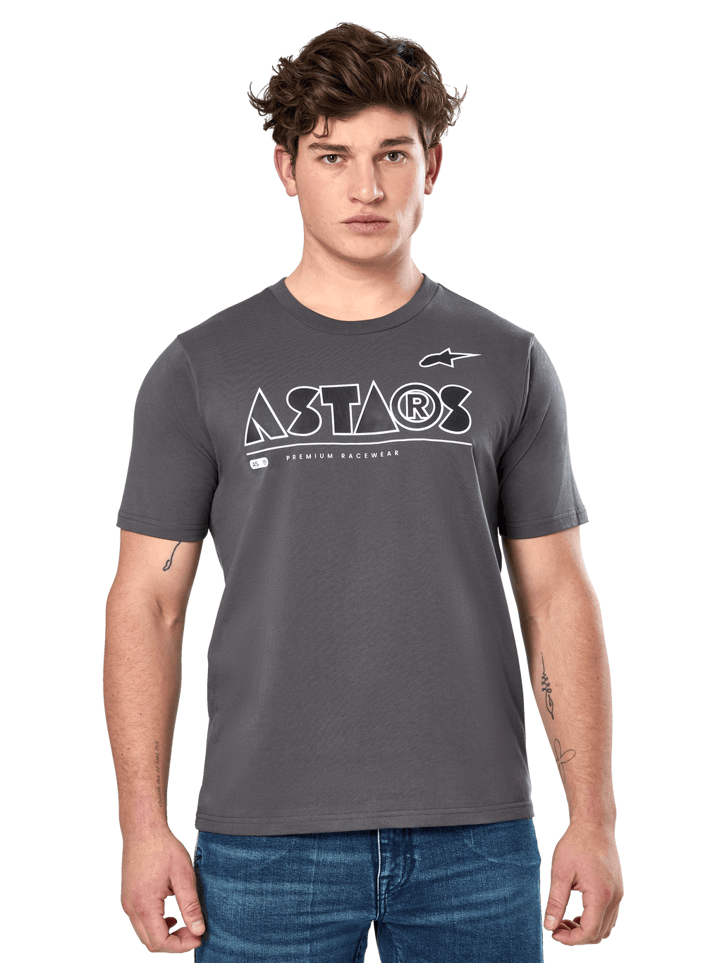 Alpinestars Cereal CSF Tee, Charcoal Gray Short Sleeve T-Shirt, worn by a male model with blue jeans, white ASTARS geometric logo and 'Premium Racewear' text, casual motorsport-inspired lifestyle apparel
