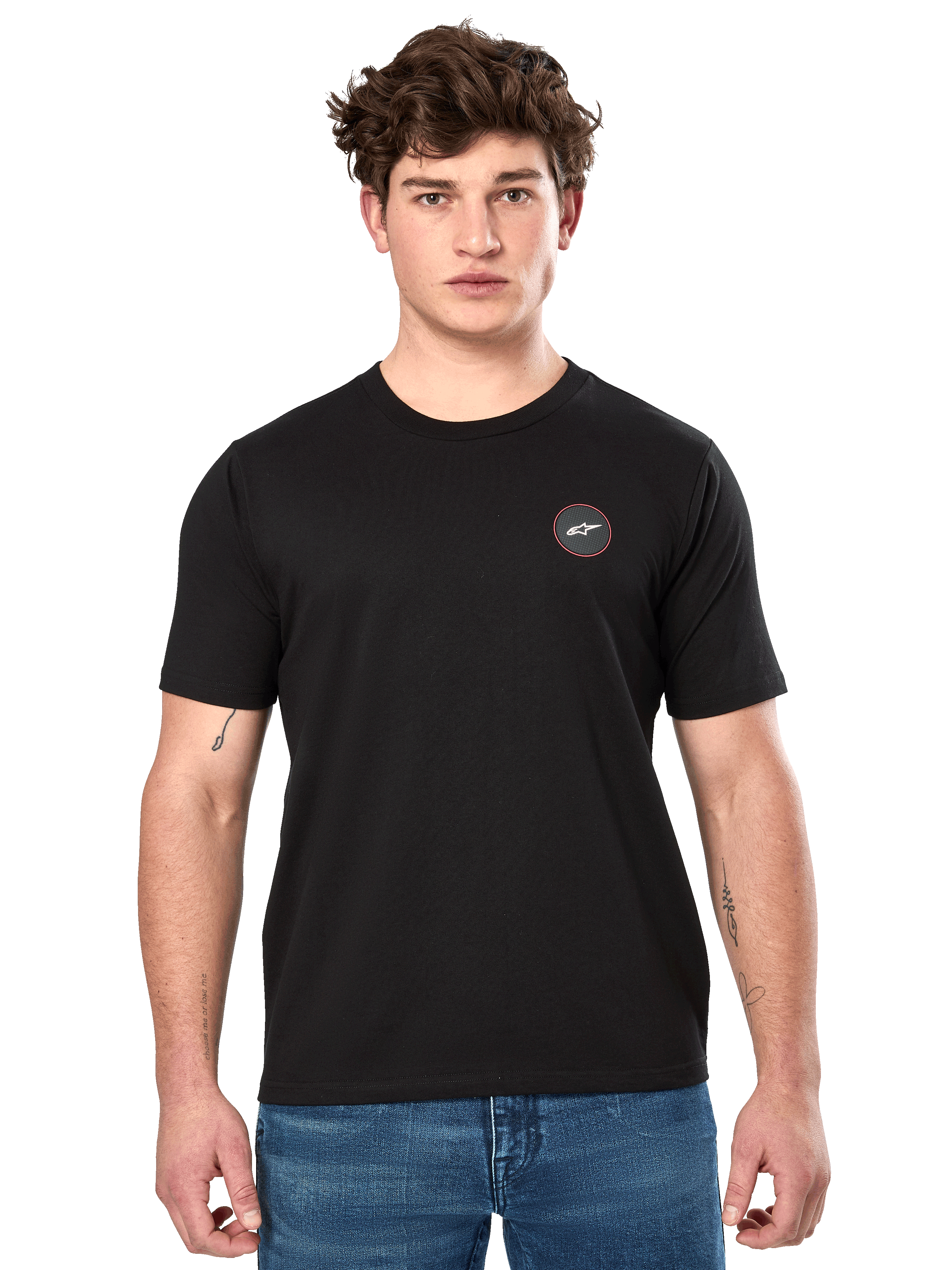Alpinestars Dot Carbon CSF Tee, Kurzarm-T-Shirt, Schwarz, kleines rundes Brustlogo mit weißem Astar und roter Umrandung, von einem Model mit blauen Jeans getragen, lässige Motorsport-Streetwear