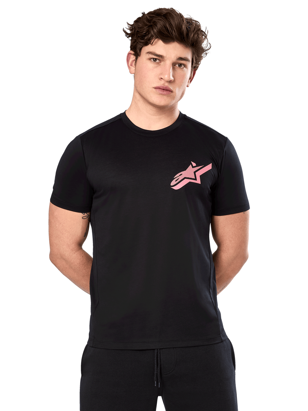 Alpinestars Attrition Performance Tee, kurzärmeliges T-Shirt, Schwarz mit rosa Astars-Logo auf der Brust, getragen von einem männlichen Model, lässige Motorsport-Performance-Bekleidung