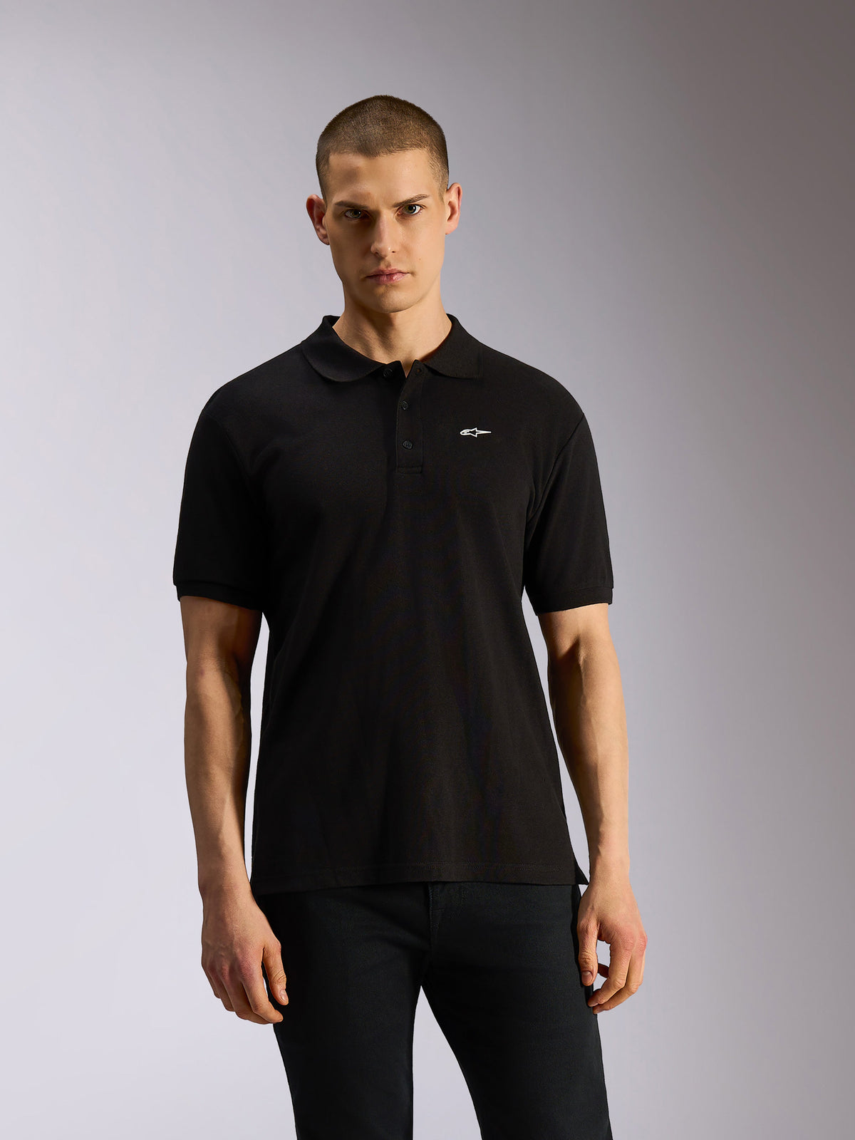 Alpinestars Endeavor Classic Polo, schwarzes Sportswear-Poloshirt, kurze Ärmel mit kleinem weißem Astars-Logo auf der Brust, Drei-Knopf-Leiste, klassischer Piqué-Strick, lässiger Motorsport-inspirierter Stil