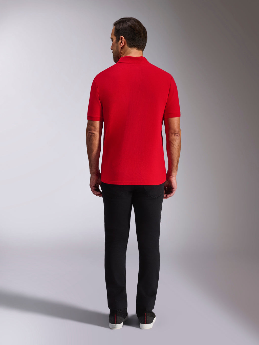 Alpinestars Endeavor Classic Polo, rotes Piqué-Poloshirt, Rückansicht, kombiniert mit einer schwarzen Hose, lässige Motorsport-Streetwear mit Rippkragen und Ärmelbündchen