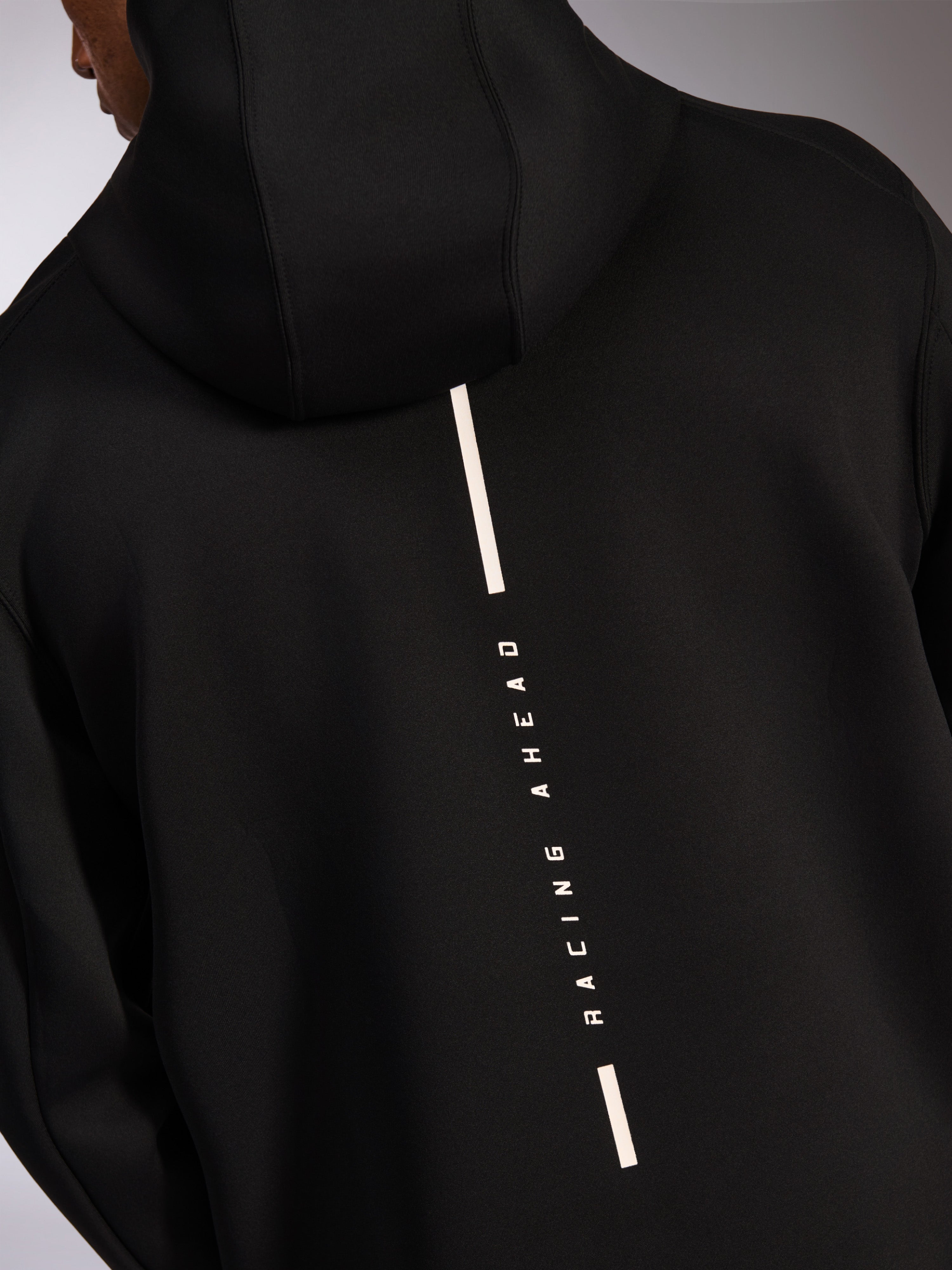 Alpinestars Insight Hoodie, lässiger Sportswear-Kapuzenpullover, Schwarz, Rückansicht mit vertikalem weißem Racing Ahead-Streifenlogo, glattes Tri-Blend-Doppelvlies, modernes, vom Motorsport inspiriertes Design