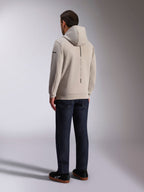 Alpinestars Insight Hoodie, Rückansicht in Zementgrau, mit vertikalem schwarzen Streifen und „RACING AHEAD“ Schriftzug, lässiges Streetwear-Design, kombiniert mit dunkler Jeans und schwarzen Schuhen.