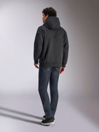 Alpinestars Emergent Oversized Hoodie, Schwarz, Rückansicht mit 3D-gesticktem Alpinestars-Wortlogo über den Schultern, Oversize-Passform, kombiniert mit dunkelblauer Denim-Jeans und schwarzen Sneakern, lässige, vom Motorsport inspirierte Streetwear