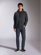 Alpinestars Emergent Oversized Hoodie, lässige Lifestyle-Streetwear, Schwarz mit tonalem 3D-Sticklogo, Kapuze mit Kordelzug, Kängurutasche, Oversized-Passform, getragen von einem Model mit dunkelblauen Jeans und schwarzen Sneakern