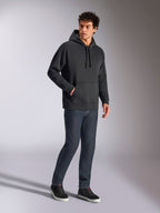 Alpinestars Emergent Oversized Hoodie, schwarze lässige Streetwear, tonales 3D-besticktes Astars-Logo auf der Brust, Kängurutasche, Oversized-Passform, getragen von einem männlichen Model mit dunkelblauen Jeans und schwarzen Sneakern