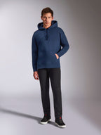 Alpinestars Emergent Oversized Hoodie, marineblauer Fleece-Kapuzenpullover, farblich abgestimmte 3D-Logostickerei auf der Vorderseite, getragen von einem Modell mit schwarzer Hose und Sneakern, lässiger Streetwear-Stil.