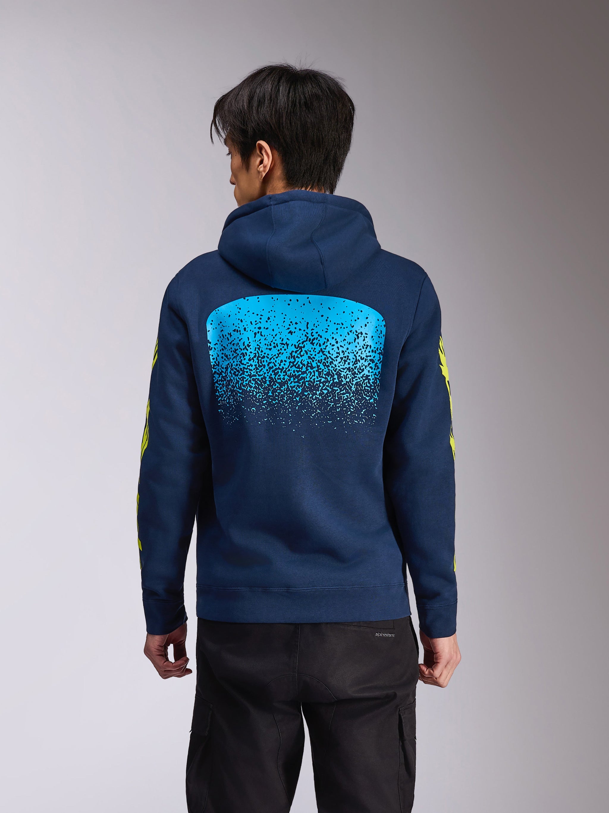 Alpinestars Obsessed Hoodie, navy blue hooded pullover fleece, back view featuring a large light blue MX gradation graphic, yellow Alpinestars wordmark on sleeves, casual motorsport-inspired streetwear