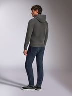 Alpinestars Ellipsoid Hoodie, lässige Sportbekleidung, Gunmetal-Grau, Rückansicht an männlichem Model, Kapuze mit Kordelzug, lange Ärmel, Rippbündchen an Ärmeln und Saum, kombiniert mit dunkler Jeans und Sneakern