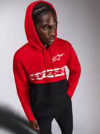 Alpinestars Parallel Kapuzenpullover, lässiger Fleece-Hoodie, rot-schwarzes Color-Block-Design, weißes Alpinestars Wortlogo und Astars Logo auf der Brust, getragen von einem Mann mit aufgesetzter Kapuze und schwarzer Hose, Motorsport-inspirierte Streetwear