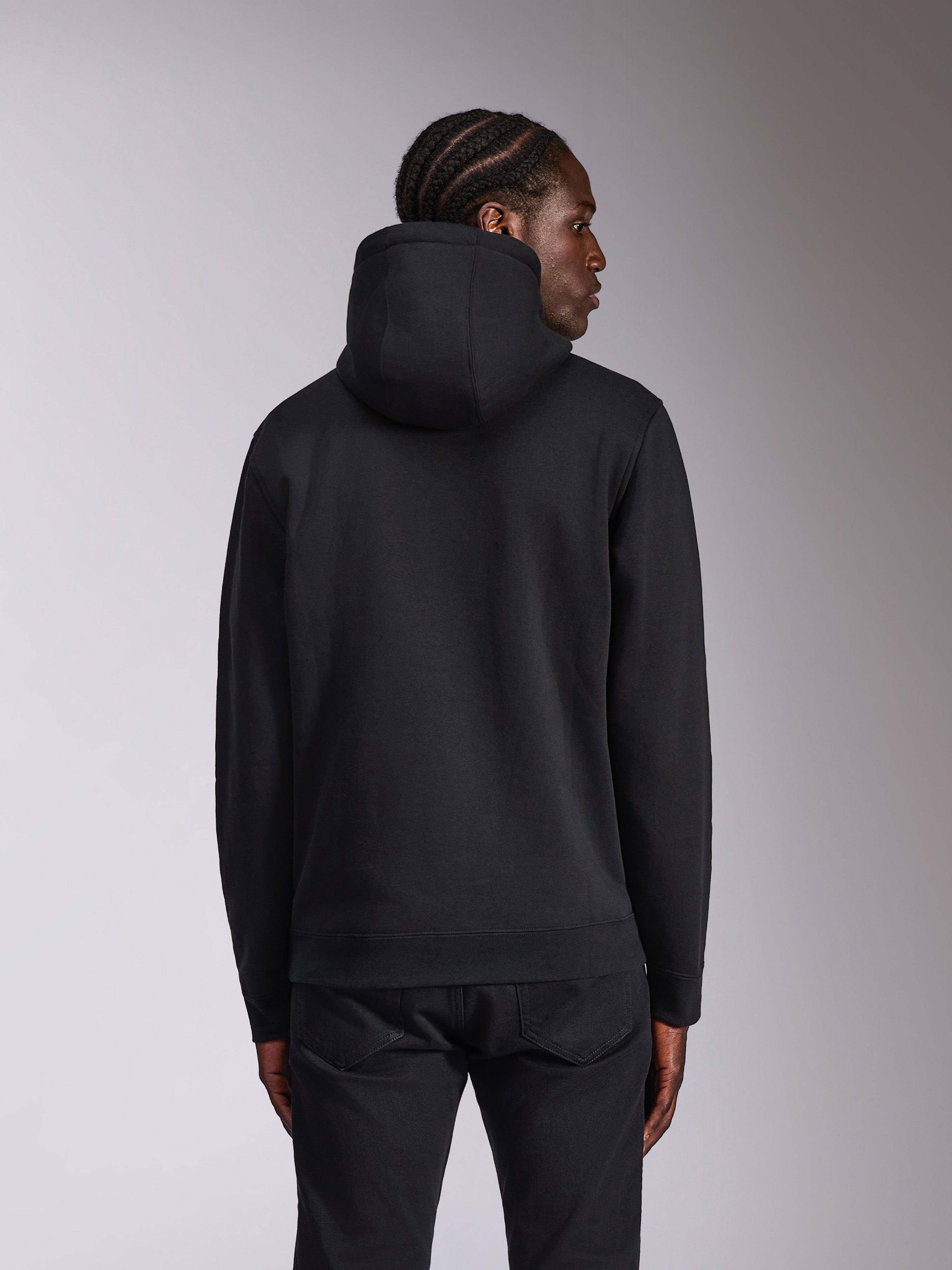 Alpinestars Pulse Hoodie, Schwarz, Rückansicht am Modell, lässige Streetwear, Kapuzenpullover aus Fleece in schlichtem Schwarz, Rippbündchen an Ärmeln und Saum, kombiniert mit schwarzer Hose