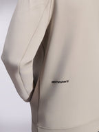 Alpinestars Cypher Hoodie, Zip-Hoodie aus Double-Face-Fleece, Cement Gray, Nahaufnahme des kleinen schwarzen Alpinestars-Wortlogos am unteren Rücken, Detail einer Nahttasche und glatte Stofftextur