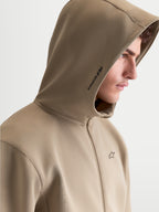 Alpinestars Cypher Hoodie, Sportswear-Kapuzenjacke mit Reißverschluss für Herren, Putty Beige. Profilansicht am Modell mit hochgeschlossener Kapuze inklusive Mesh-Futter, Alpinestars-Branding an der Seite und Logo auf der Brust. Hochwertiges Tri-Blend-Fleece für einen modernen Motorsport-Look.