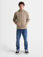 Alpinestars Cypher Hoodie, Herren-Sportswear-Fleecejacke mit durchgehendem Reißverschluss in Beige, mit einer Kapuze mit hohem Kragen, dezenten Nahttaschen und einem cleanen, vom Motorsport inspirierten Design mit einem kleinen schwarzen Alpinestars-Logo auf der Brust.