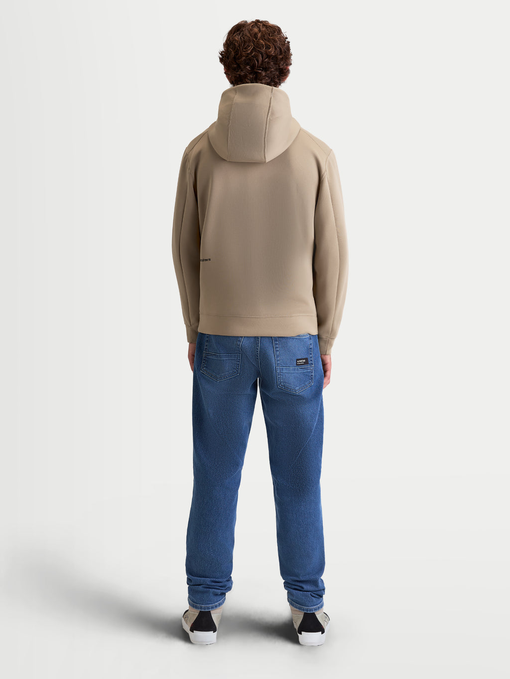 Alpinestars Cypher Hoodie, Sportswear-Fleece-Hoodie für Herren und Damen, Putty Beige, Rückansicht am Modell, Kapuze mit hohem Kragen und Mesh-Futter, Tri-Blend-Performance-Gewebe, motorsport-inspirierte Freizeitkleidung.
