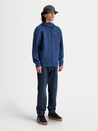 Alpinestars Cypher Hoodie, Sportswear-Fleece-Hoodie mit Frontreißverschluss, Unisex, Blau, technisches Tri-Blend-Gewebe, Kapuze mit hohem Kragen und Mesh-Futter, Nahttaschen, Ganzkörperansicht am Model in einer vom Motorsport inspirierten Passform.