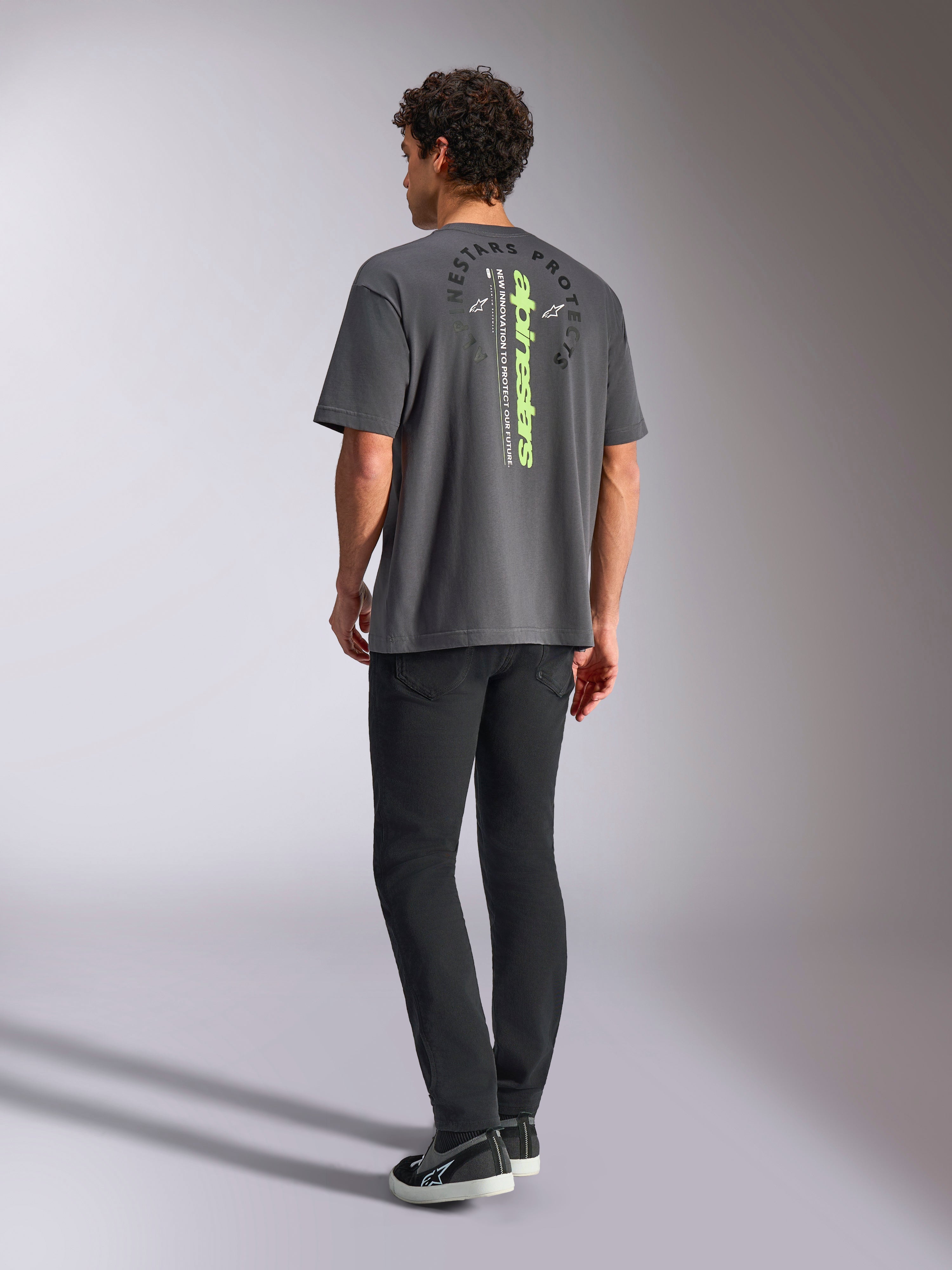 Alpinestars Overhang Oversized CSF Tee, Kurzarm-T-Shirt, Anthrazit, mit vertikalem lindgrünem Schriftzug und kreisförmiger „Alpinestars Protects“-Grafik auf der Rückseite, lässige Motorsport-Streetwear