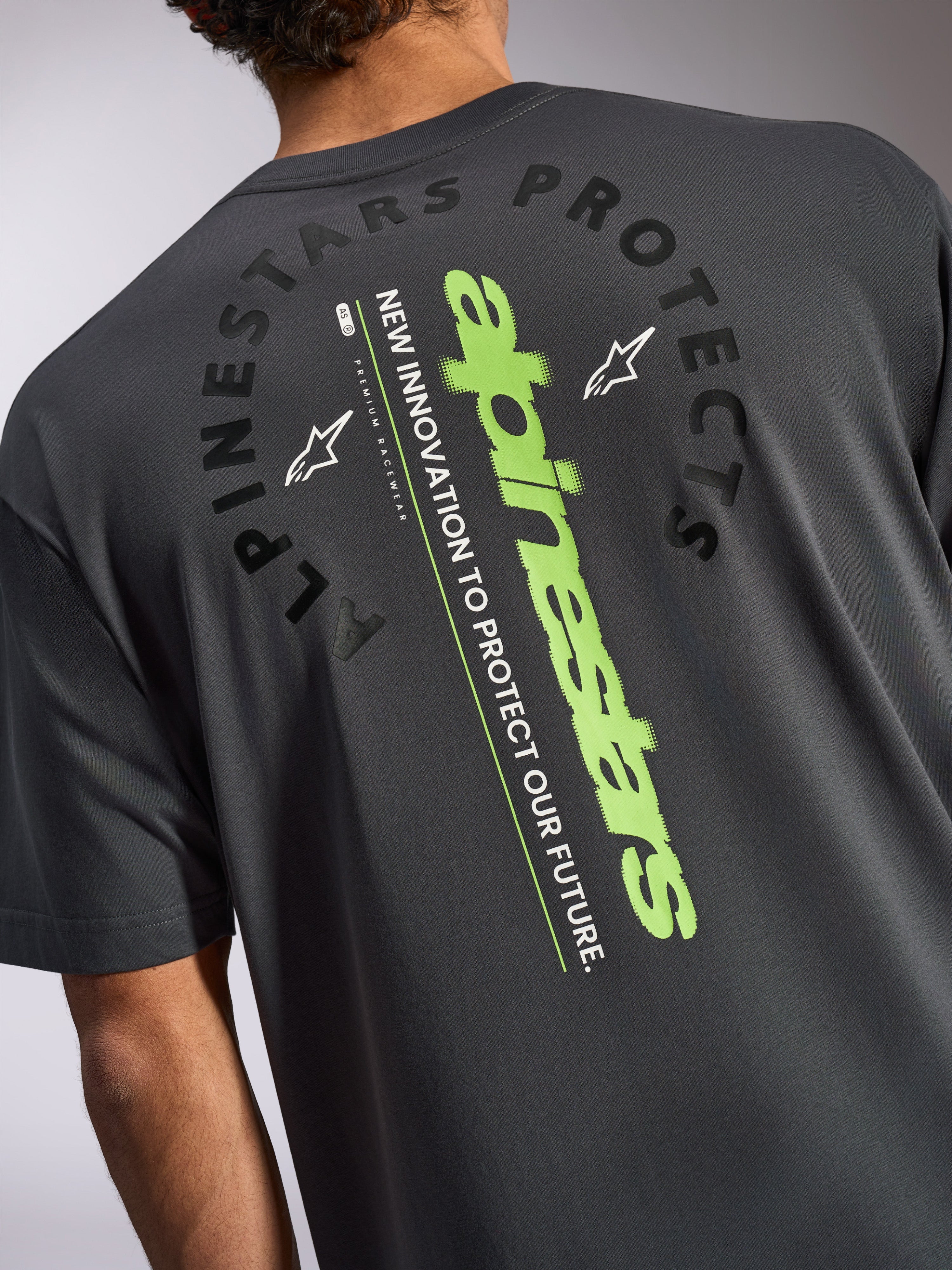Alpinestars Overhang Oversized CSF Tee, Kurzarm-T-Shirt, Anthrazitgrau, Rückansicht mit großem vertikalen limettengrünen Logo und schwarzer „Alpinestars Protects“-Grafik, lässige vom Motorsport inspirierte Sportbekleidung