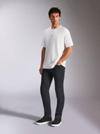 Alpinestars Focused Oversized CSF Tee, Kurzarm-T-Shirt, Weiß, mit kleinem schwarzen Astars-Logo auf der Brust, getragen von einem männlichen Model mit dunkler Hose und schwarzen Sneakern, lässige, vom Motorsport inspirierte Streetwear