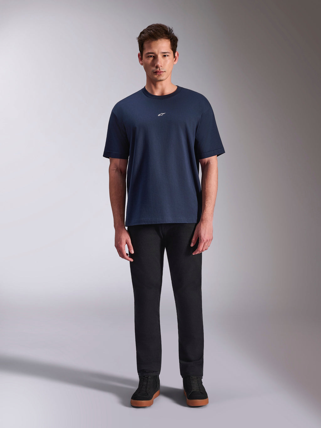 Alpinestars Focused Oversized CSF Tee, Kurzarm-T-Shirt, Marineblau, kleines weißes Astars-Logo auf der Brust, Oversized-Passform, kombiniert mit schwarzer Hose und schwarzen Sneakern, lässige Motorsport-Streetwear