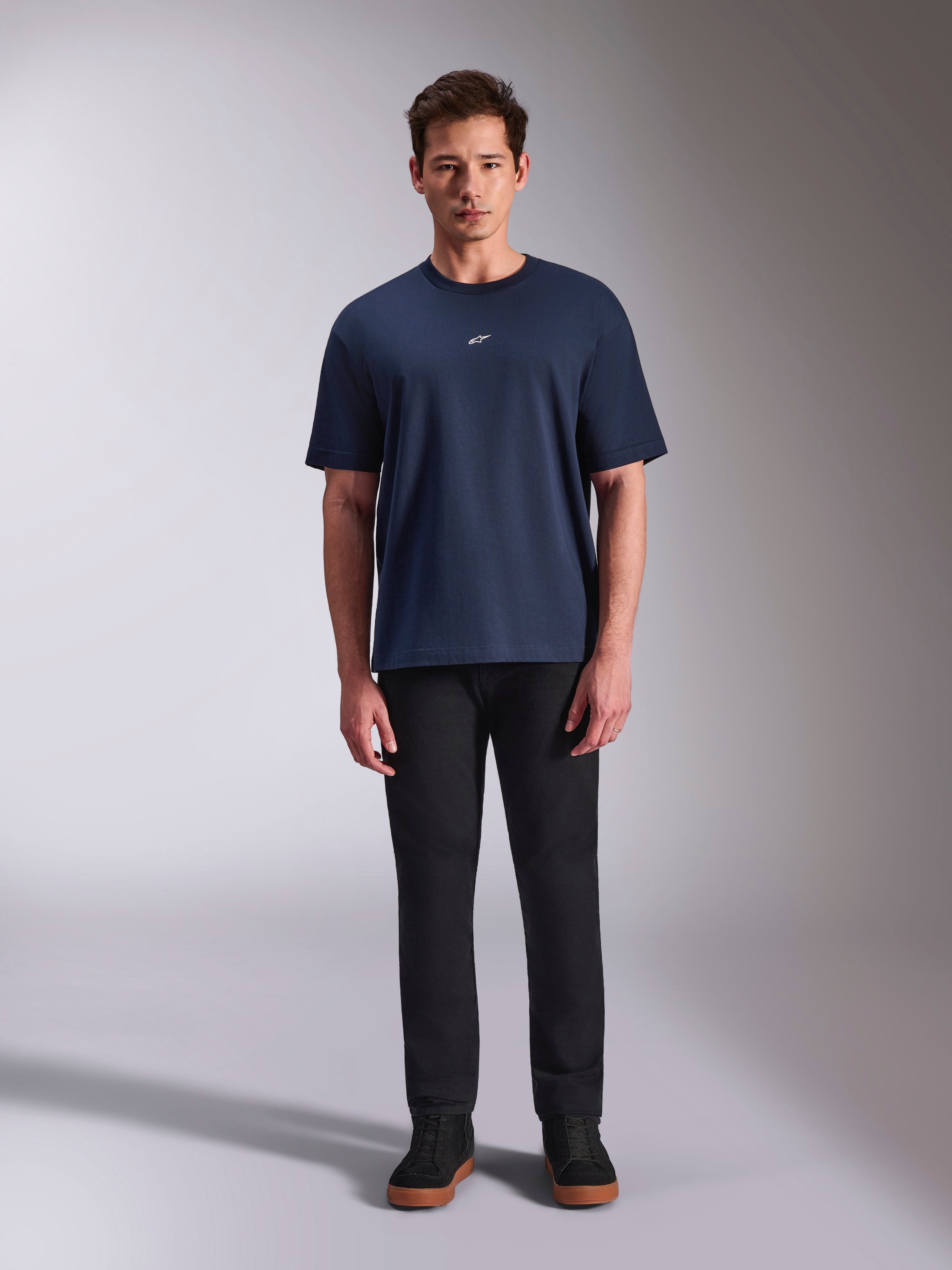 Alpinestars Focused Oversized CSF Tee, Kurzarm-T-Shirt, Marineblau, kleines weißes Astars-Logo auf der Brust, Oversized-Passform, kombiniert mit schwarzer Hose und schwarzen Sneakern, lässige Motorsport-Streetwear
