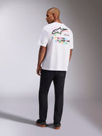 Alpinestars Wild Oversized CSF Tee, Kurzarm-T-Shirt, Weiß, Rückansicht eines Modells, das ein Oversized-T-Shirt mit lebhaftem mehrfarbigem Astars-Logo und gestapeltem Text auf der Rückseite trägt, lässige, vom Motorsport inspirierte Streetwear