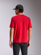 Alpinestars Noka CSF Tee, Kurzarm-T-Shirt, Rot, Rückansicht am Model, lässige Motorsport-Streetwear, kombiniert mit schwarzer Kappe und dunkler Hose