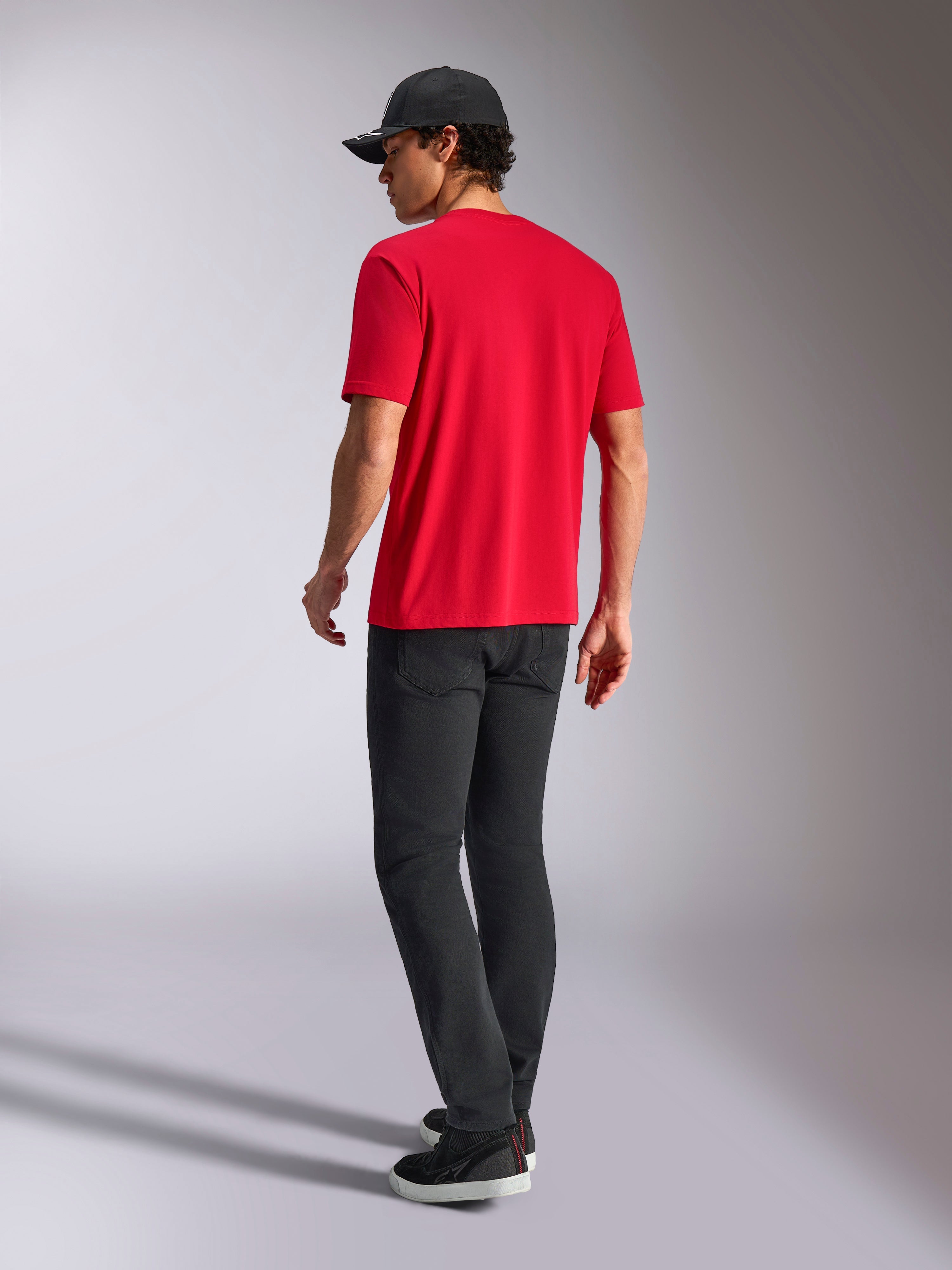 Alpinestars Noka CSF Tee, Kurzarm-T-Shirt, Rot, Rückansicht, kombiniert mit schwarzer Hose und schwarzer Baseballcap, lässige vom Motorsport inspirierte Streetwear