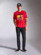 Alpinestars Noka CSF Tee, Kurzarm-T-Shirt, Rot, mit einem großen Astars-Logo auf der Vorderseite mit gelbem und schwarzem MX-Farbverlauf, getragen mit schwarzer Hose und schwarzer Kappe, Casual Motorsport Streetwear
