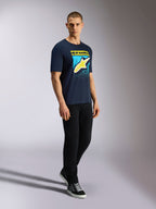 Alpinestars Noka CSF Tee, Kurzarm-T-Shirt, Navy, Gelbes Astars-Logo mit blauer MX-Verlauf-Grafik, Männliches Model trägt navyblaues T-Shirt mit schwarzer Hose und Sneakern, Lässige Motorsport-Streetwear