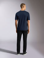 Alpinestars Noka CSF T-Shirt, kurzärmliges T-Shirt, Marineblau, Rückansicht eines Mannes in schwarzer Hose und Sneakern, lässige Motorsport-Streetwear