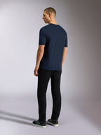 Alpinestars Noka CSF Tee, kurzärmeliges T-Shirt, Marineblau, Rückansicht an einem Model mit schwarzer Hose und Sneakern, lässige Motorsport-Streetwear