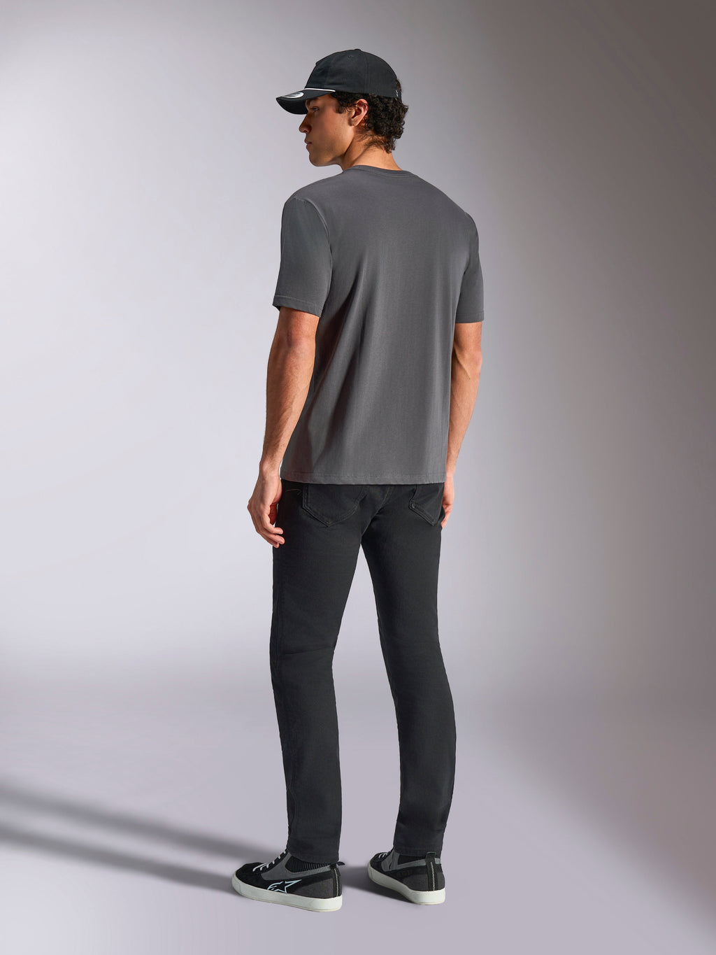 Alpinestars Ellipsoid CSF Tee, Kurzarm-T-Shirt, Anthrazit, Rückansicht, getragen von einem Model mit schwarzer Hose und schwarzer Baseballkappe, lässige Motorsport-Streetwear