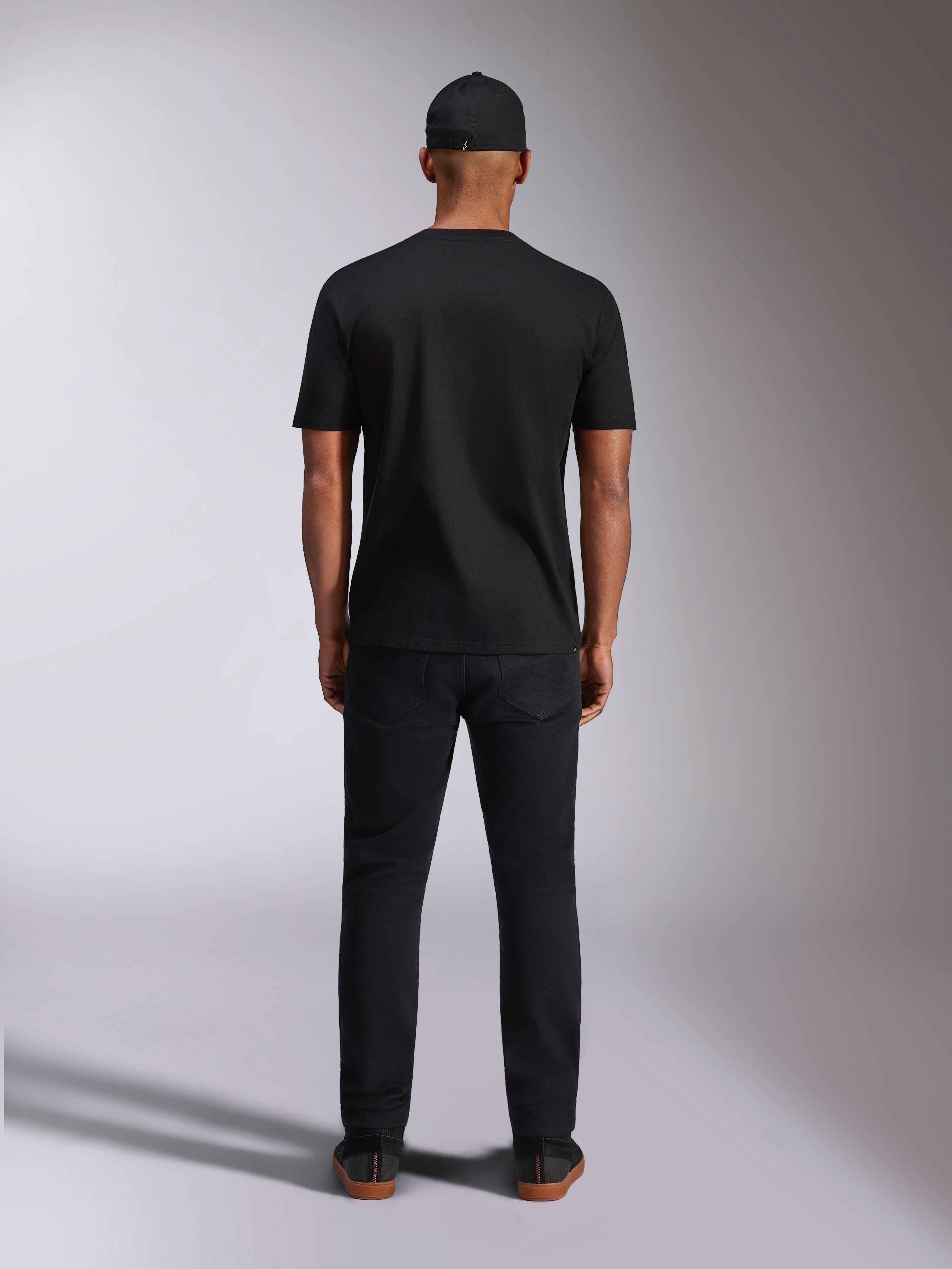 Alpinestars Plate CSF Tee, Kurzarm-T-Shirt, Schwarz, Rückansicht am Model, getragen mit schwarzer Kappe und Hose, lässige Motorsport-Streetwear