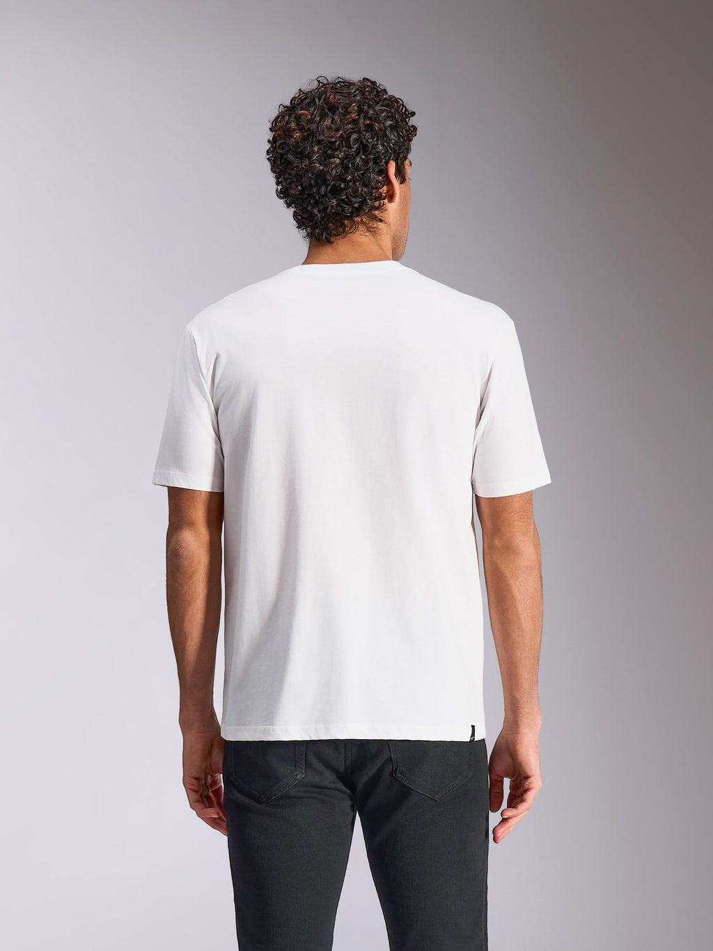 Alpinestars Plate CSF Tee, Kurzarm-T-Shirt, Weiß, Rückansicht, getragen mit einer schwarzen Hose, lässige Motorsport-Streetwear