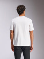 Alpinestars Plate CSF Tee, Kurzarm-T-Shirt, Weiß, Rückansicht, getragen mit einer schwarzen Hose, lässige Motorsport-Streetwear