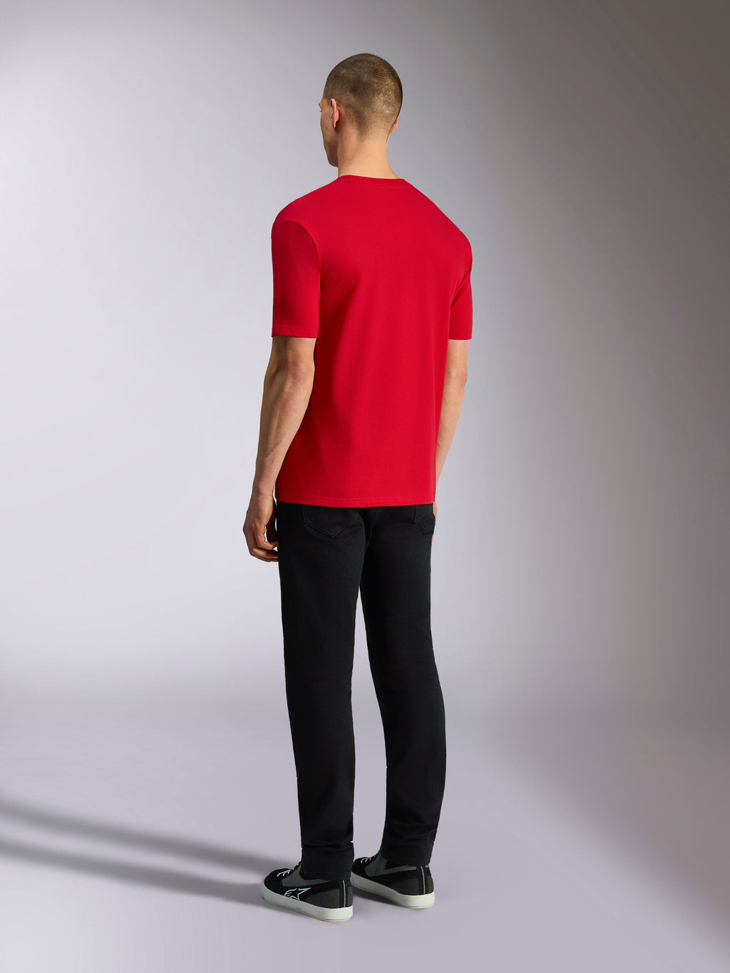 Alpinestars Plate CSF Tee, Kurzarm-T-Shirt, Rot, Rückansicht, getragen mit schwarzer Hose und Sneakern, lässige Motorsport-inspirierte Streetwear