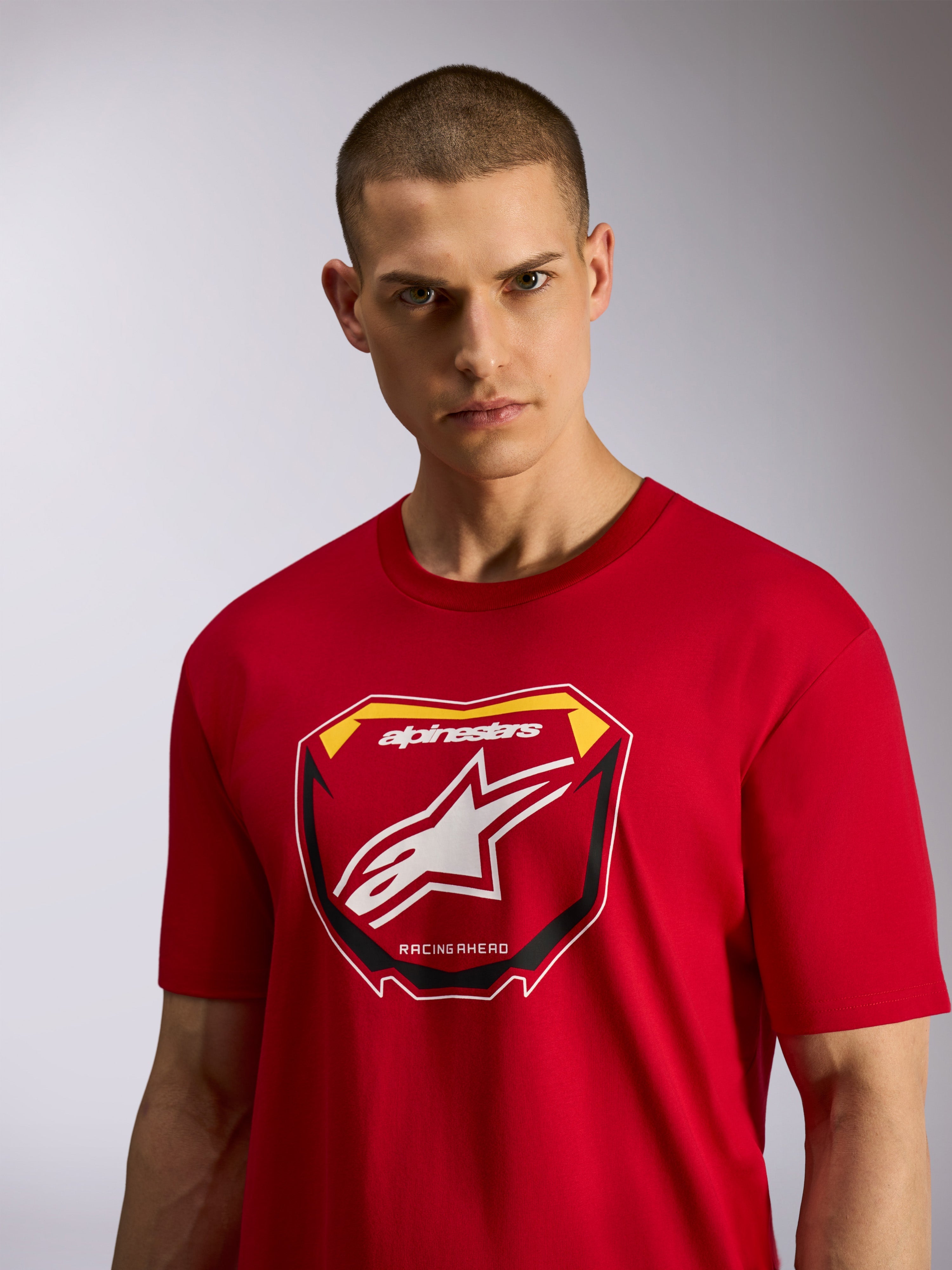 Alpinestars Plate CSF T-Shirt, kurzärmeliges T-Shirt, Rot, mit MX-Plattengrafik auf der Vorderseite, Alpinestars-Logo und „Racing Ahead“-Schriftzug, getragen von einem männlichen Model, lässige vom Motorsport inspirierte Sportbekleidung