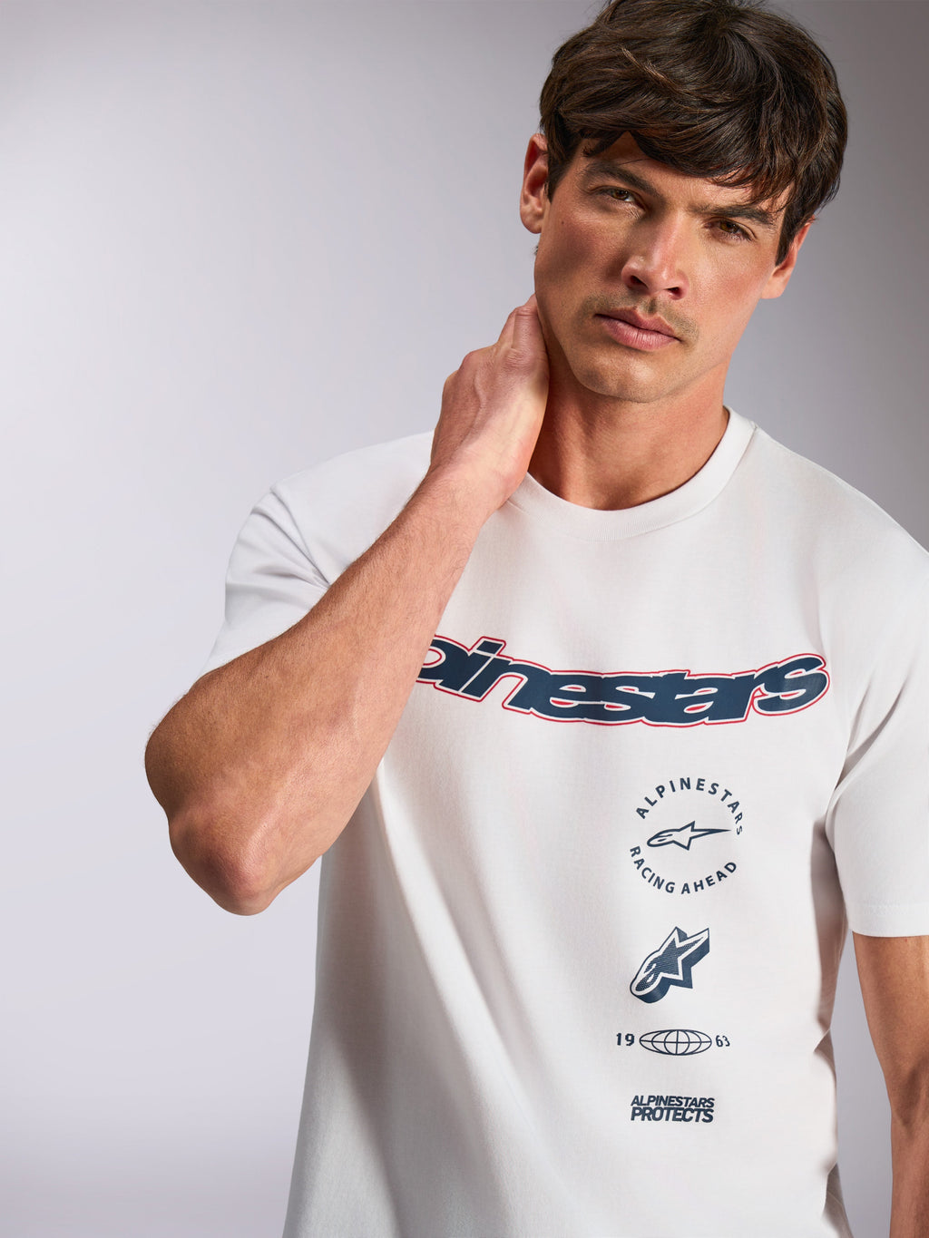 Alpinestars Abus CSF Tee, kurzärmeliges T-Shirt, Weiß, mit marineblauem, geschwungenem Alpinestars-Logo mit roter Umrandung und mehrfach gestapelten Grafiken, lässige Motorsport-Streetwear