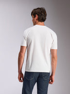 Alpinestars Abus CSF Tee, Kurzarm-T-Shirt, Weiß, Rückansicht eines Models, das ein schlichtes weißes T-Shirt und dunkelblaue Jeans trägt, lässige vom Motorsport inspirierte Lifestyle-Bekleidung