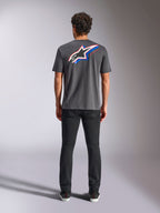 Alpinestars Angler CSF Tee, Kurzarm-T-Shirt, Charcoal, Großes mehrfarbiges Astars-Logo auf der Rückseite mit roten und blauen Akzenten, Rückansicht am Model, lässige Motorsport-Streetwear