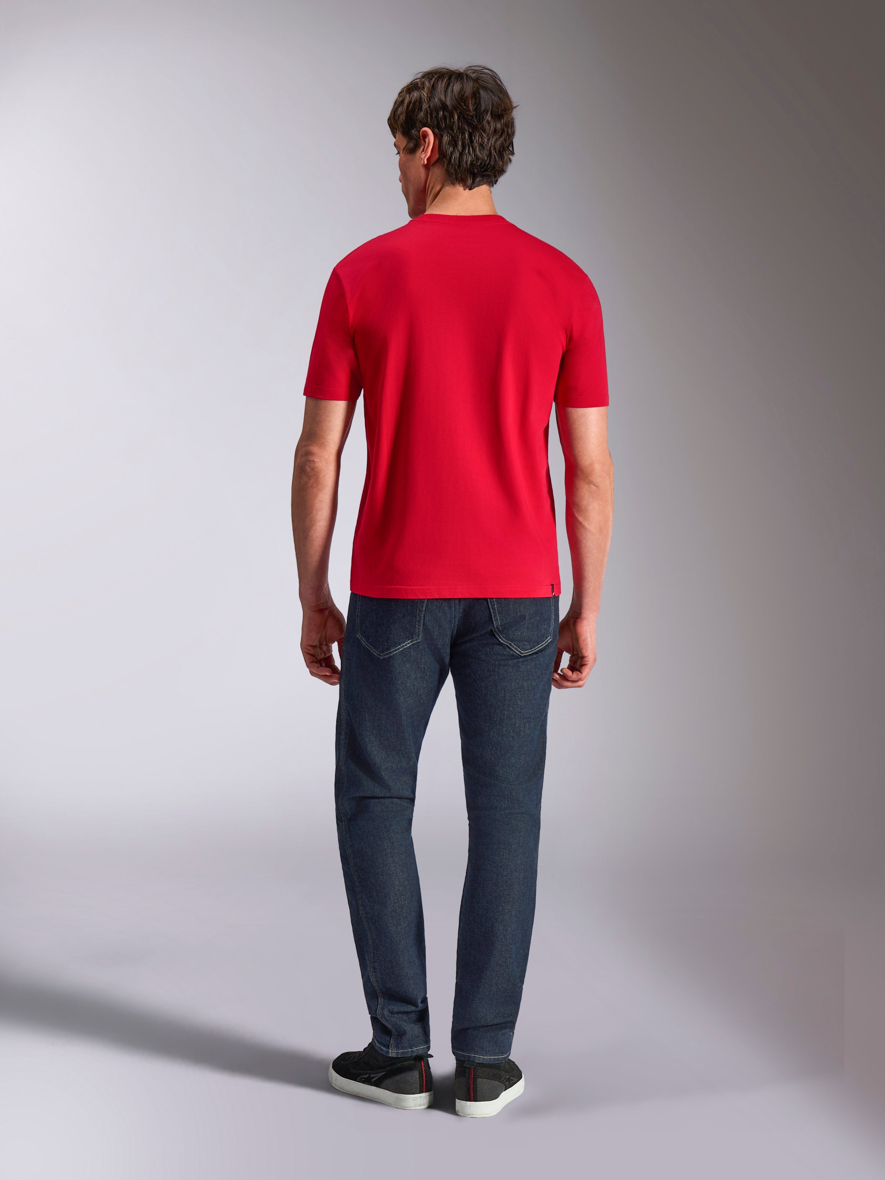 Alpinestars Authority CSF Tee, kurzärmeliges T-Shirt, Rot, Rückansicht an einem Modell in dunkelblauer Jeans und schwarzen Sneakern, lässige vom Motorsport inspirierte Streetwear