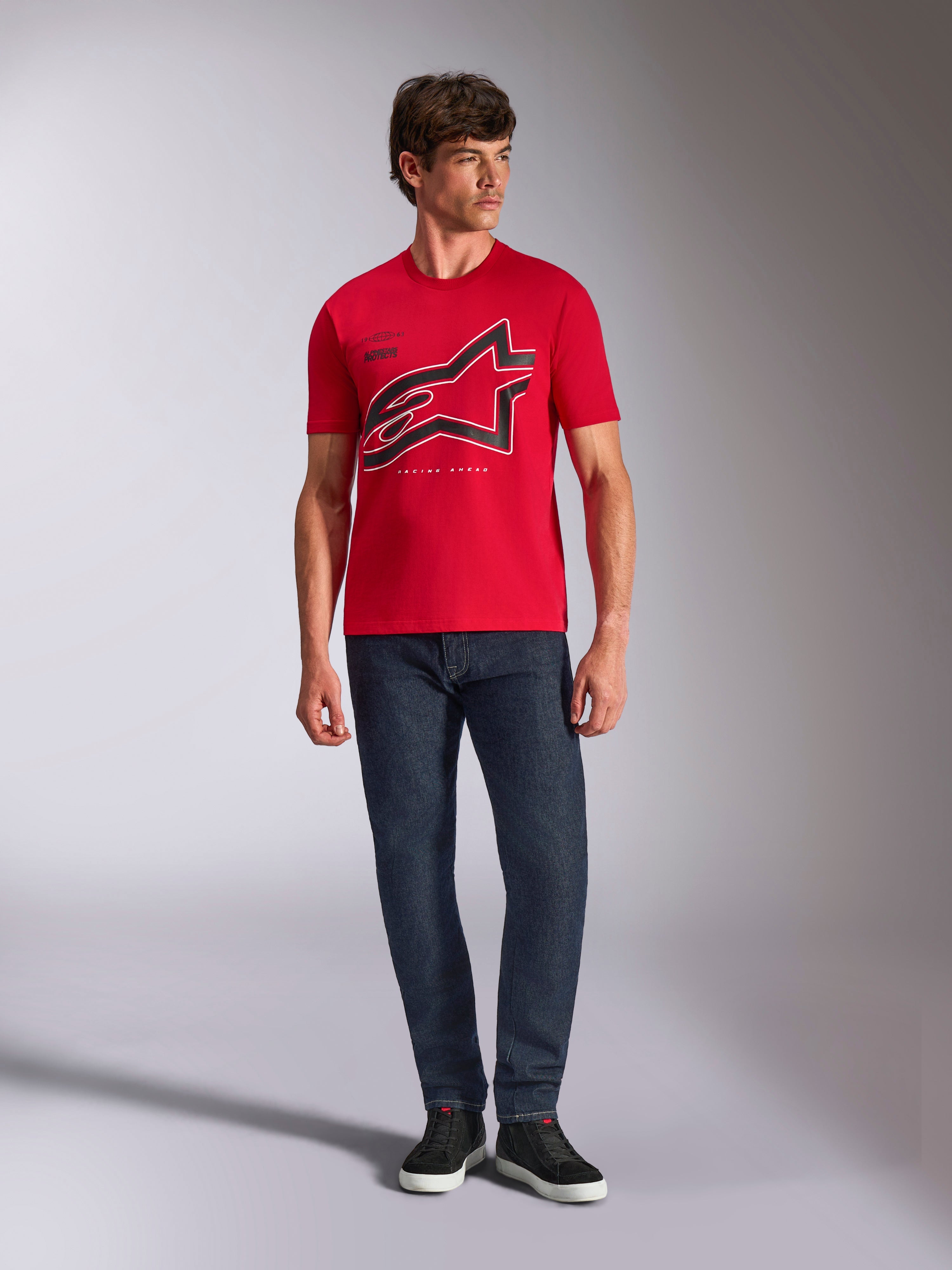 Alpinestars Authority CSF Tee, Kurzarm-T-Shirt, Rot, großes schwarzes angeschnittenes Astars-Logo mit weißer Umrandung, getragen mit dunkelblauen Jeans und schwarzen Sneakern, lässige Motorsport-inspirierte Streetwear